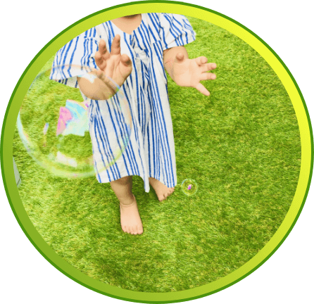 人工芝で子供がしゃぼん玉で遊んでいる